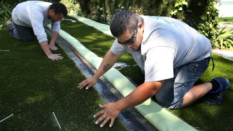 Workers install artificial grass at a home in Burlingame, California, in April.