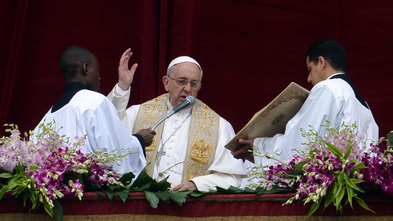 Pope Francis speaks from St. Peter's Basilica during the "urbi et orbi" blessing for Rome and the world following the Easter Mass on Sunday, April 5, at the Vatican. He lamented the suffering of people in conflicts currently making headlines and asked that bloodshed end in Iraq and Syria.