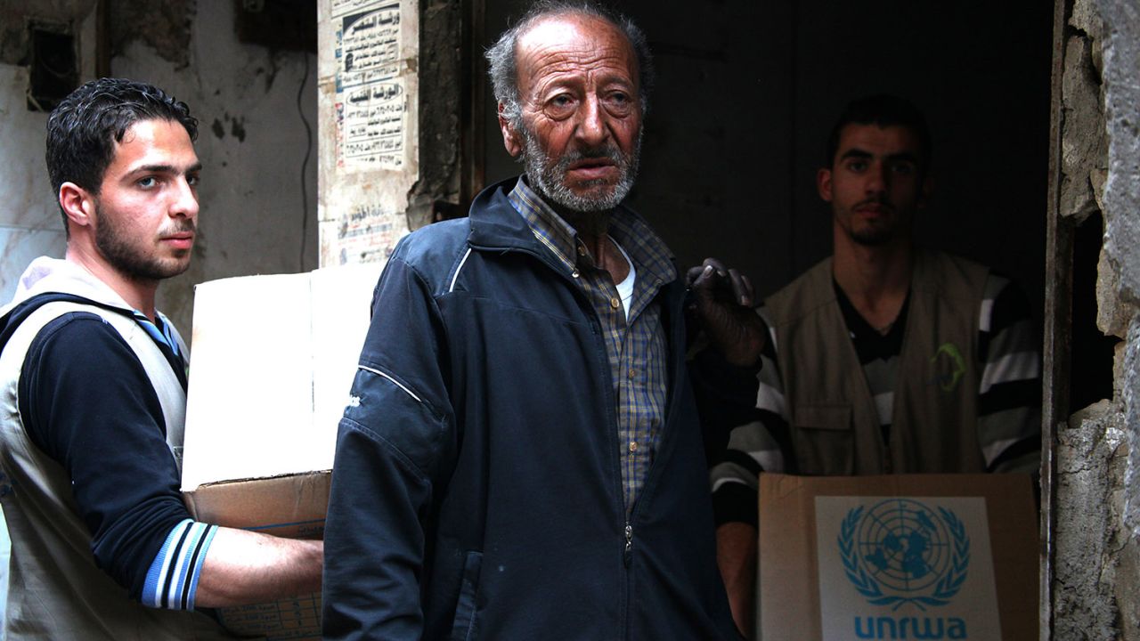 Palestinians at the Yarmouk refugee camp in Syria receive supplies from the United Nations Relief and Works Agency on March 9. 