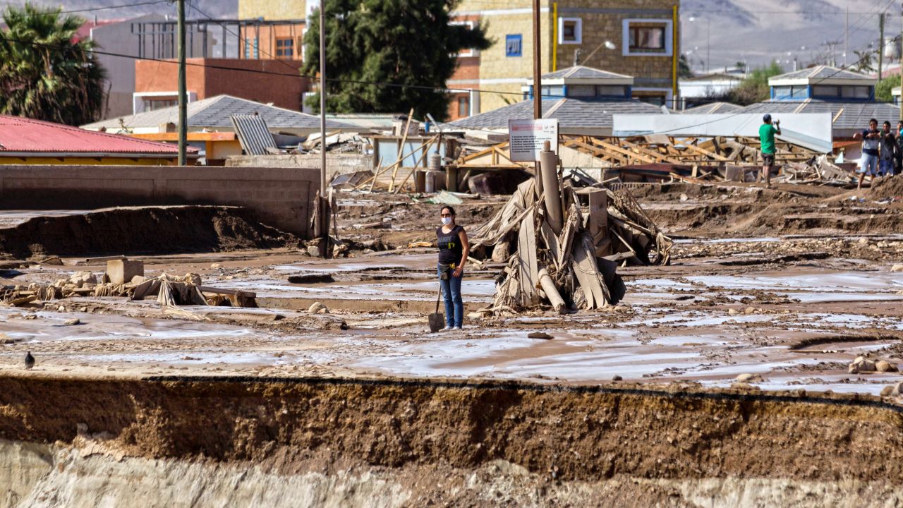 A woman stands in the muddy ruins of a flooded street in Chanaral, Chile, on April 1, after heavy rainfall caused the overflowing of the Copiapo River.