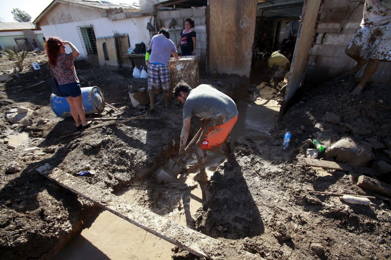 Residents shovel mud from a home in Diego de Almagro, Chile, on Saturday, March 28.