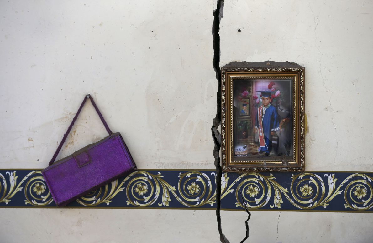 A framed photo and a purse hang on the wall of a house destroyed by an airstrike near the Sanaa airport on Tuesday, March 31.