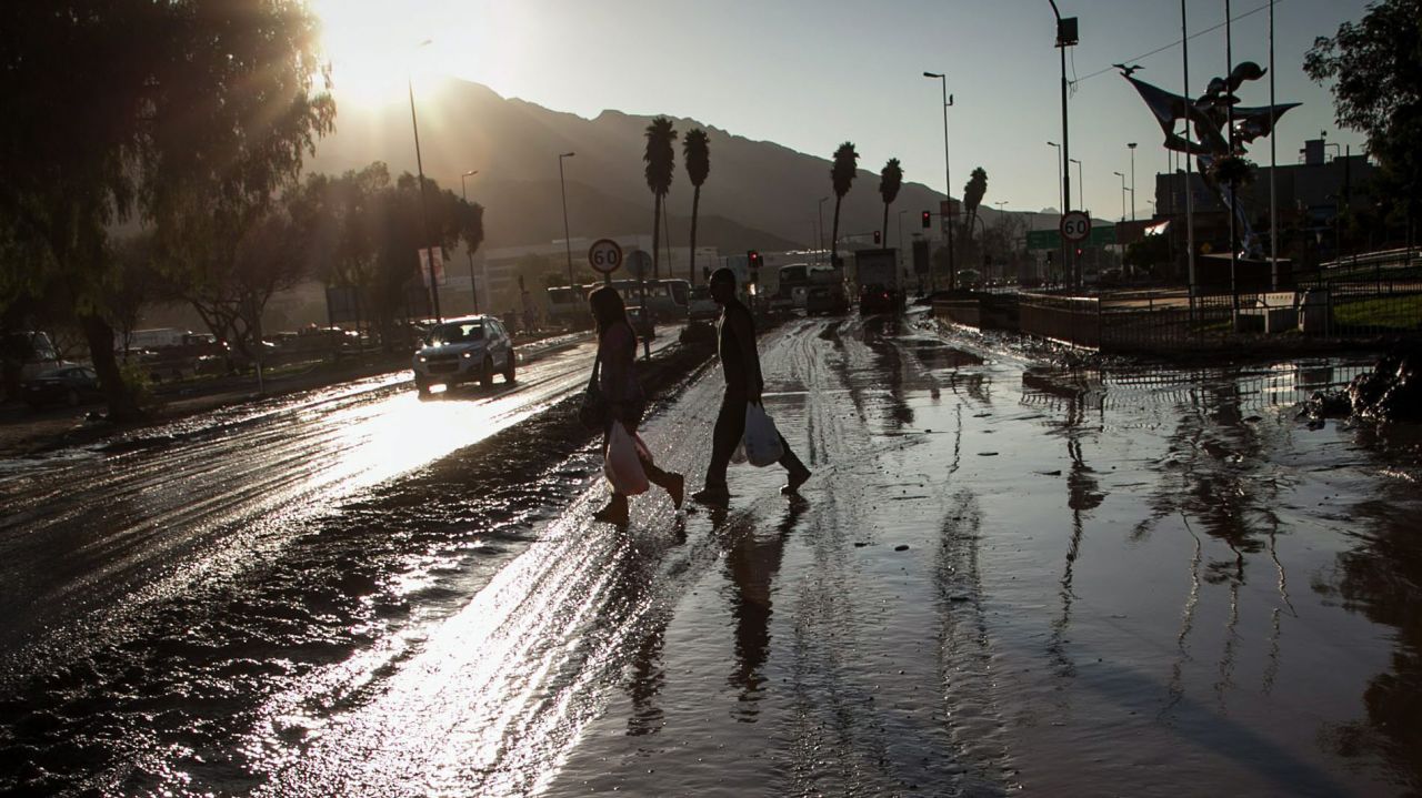 People walk on a street covered with mud in Copiapo, Chile, on Thursday, April 2. Floods in the north of the country have left killed at least 25 people and left more than 100 missing, with death tolls expected to rise. 