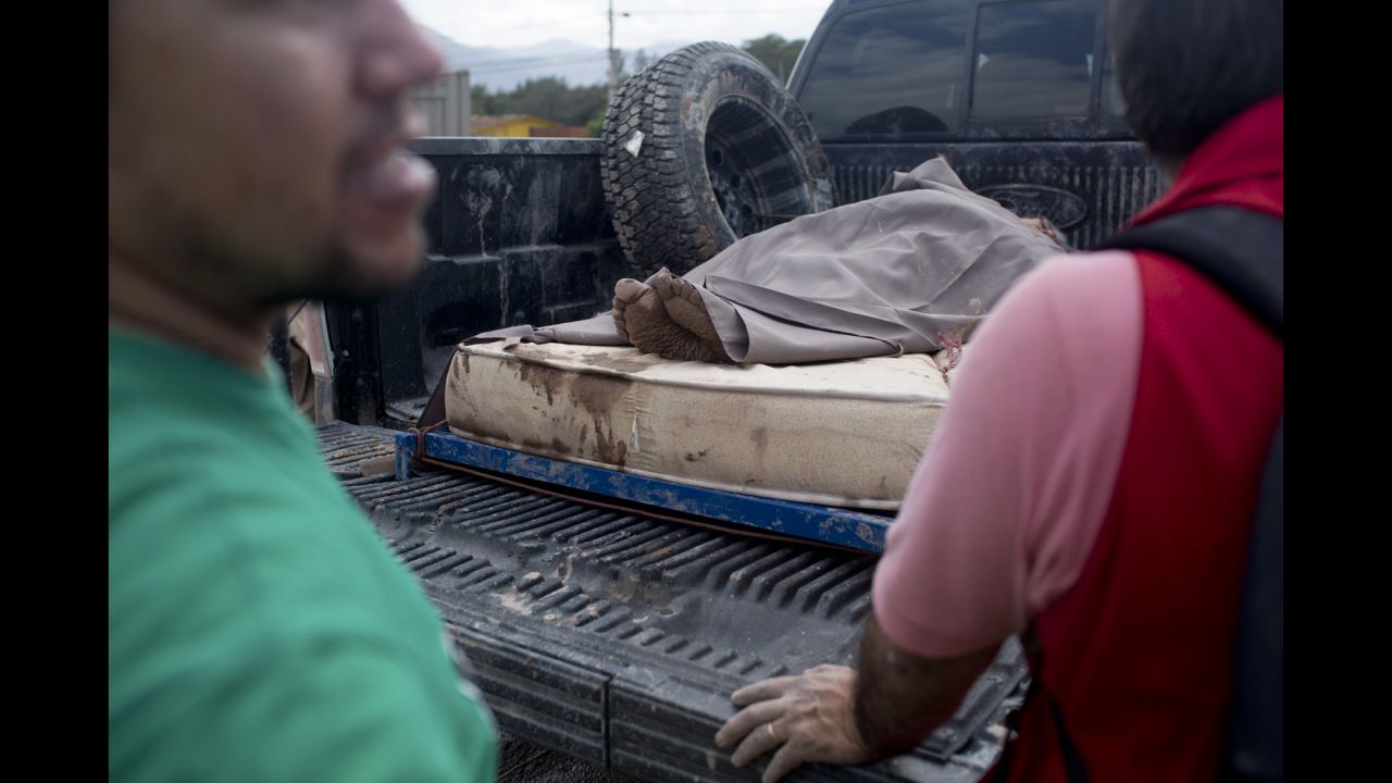 A woman rescued from the mud rests on a mattress in the back of a truck in Copiapo on March 26.