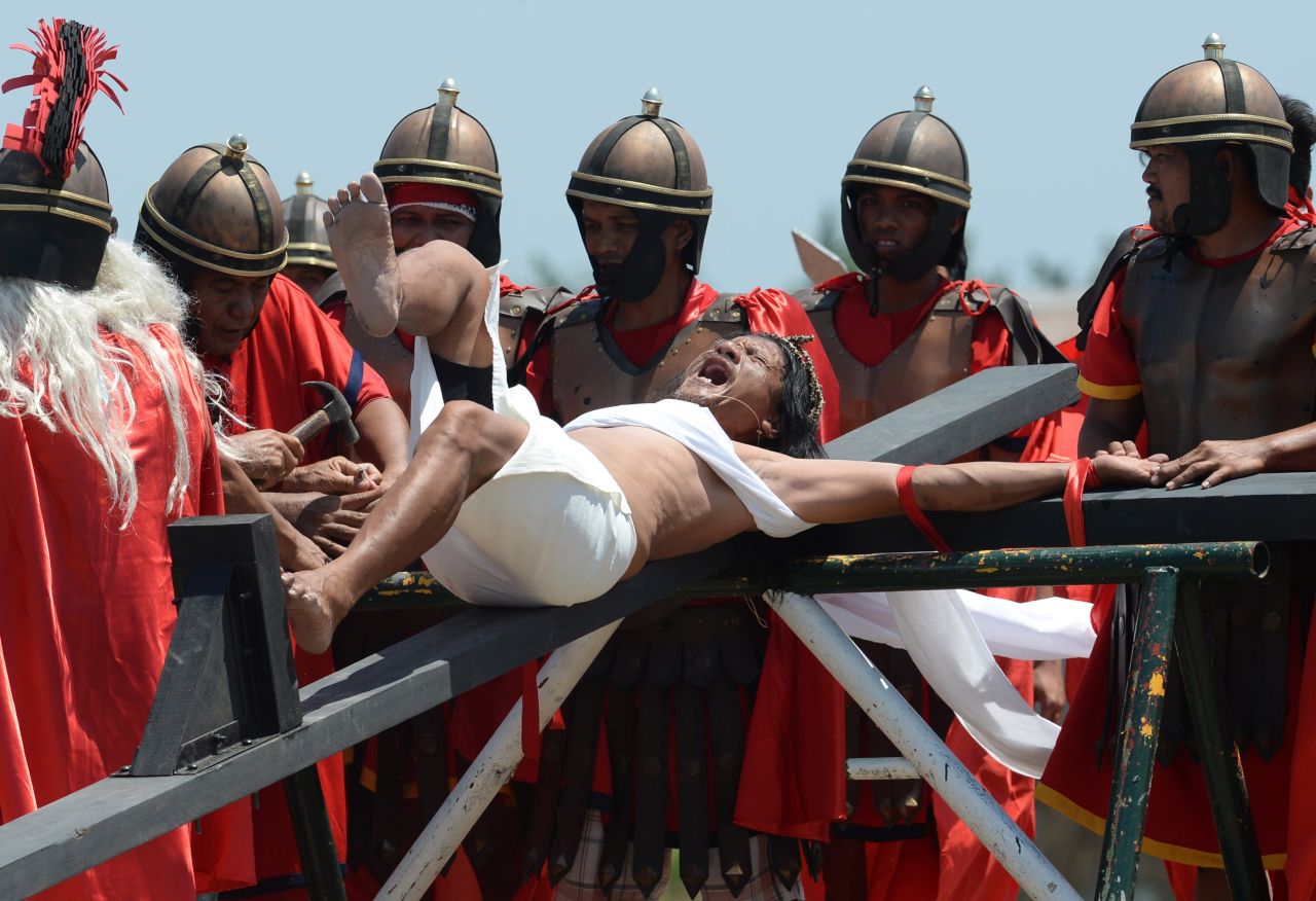 Not for the weak of heart: Penitent Ruben Enage wails in pain as he is nailed to a cross by devotees wearing costumes of Roman centurions in the village of Cutud, Philippines on April 3, 2015.