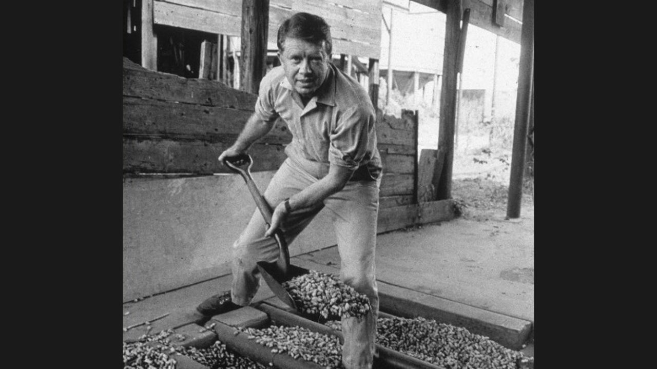 Jimmy Carter looks up while shoveling peanuts on a peanut farm sometime in the 1970s. Carter was a peanut farmer, and "Not Just Peanuts" was one of his campaign slogans during the 1976 presidential election.