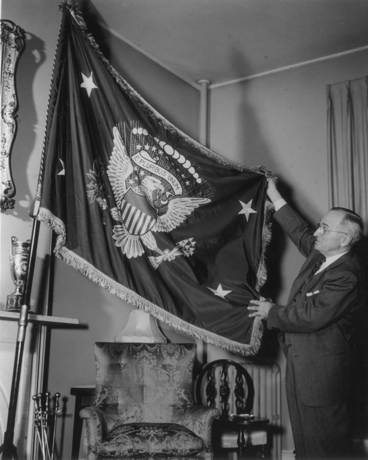 Truman holds a flag bearing the Seal of the United States, circa 1945. Truman used the slogan, "I'm just wild about Harry."