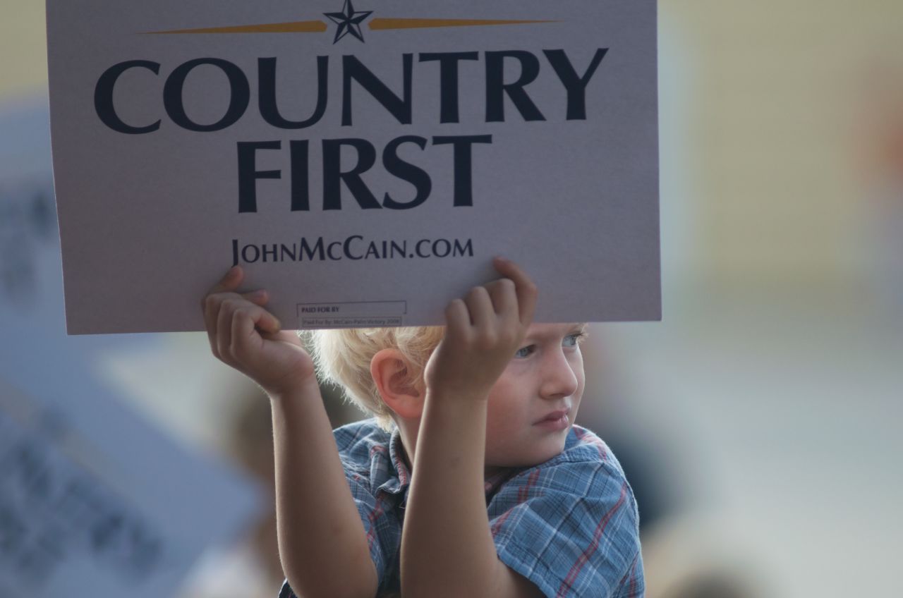 A child holds up a "Country First" sign while waiting for vice presidential candidate Alaska Gov. Sarah Palin and presidential nominee Sen. John McCain at a rally of supporters on September 18, 2008, in Cedar Rapids, Iowa.