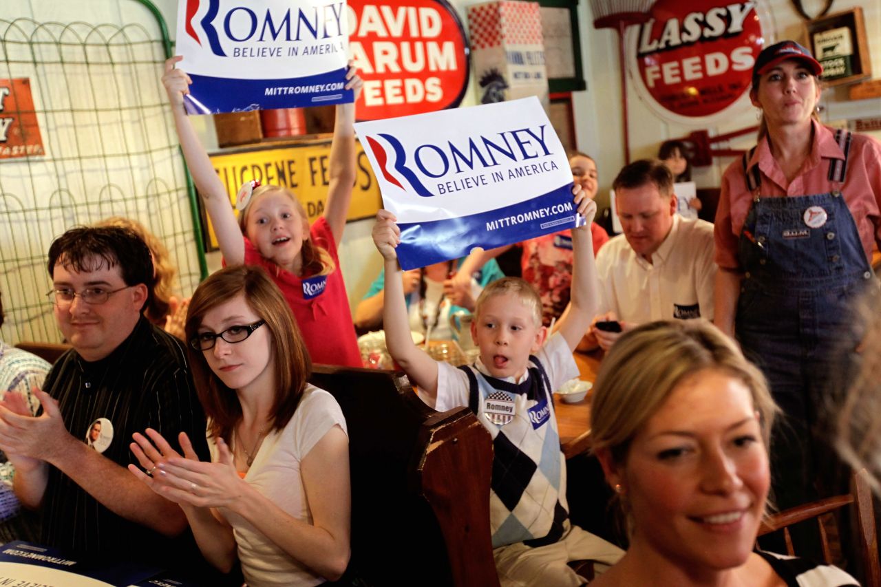 Excited supporters cheer and hold up "Believe in America" signs as Romney arrives for a campaign stop in Rockford, Illinois, on March 18, 2012.