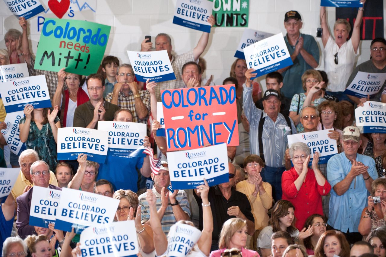 People cheer as Republican presidential candidate Mitt Romney speaks at a town hall meeting in Grand Junction, Colorado, on July 10, 2012. Supporters hold up "Colorado Believes" signs, based on Romney's "Believe in America" campaign slogan.