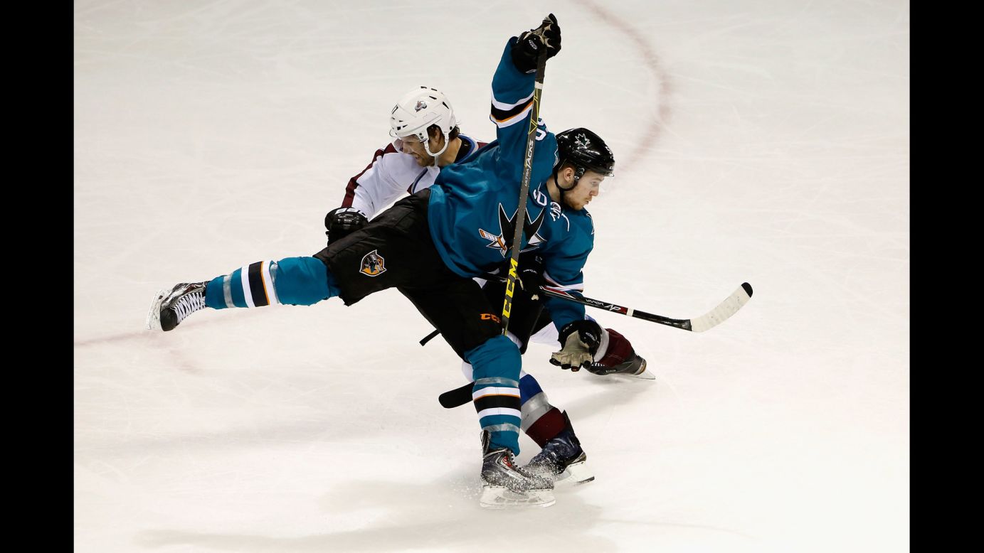 Chris Tierney of the San Jose Sharks, front, gets tangled with Brad Stuart of the Colorado Avalanche during an NHL game played Wednesday, April 1, in San Jose, California.