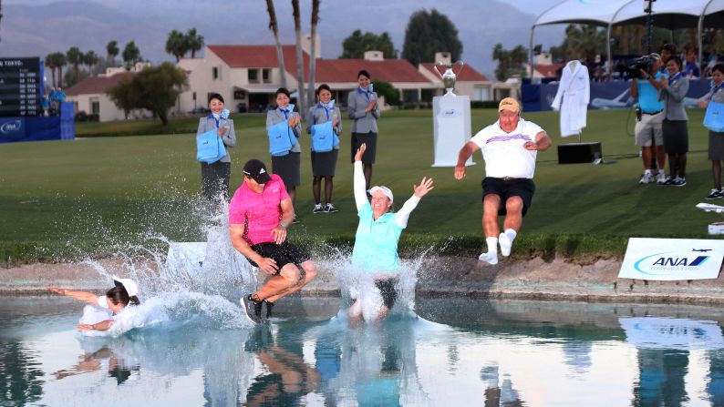 Pro golfer Brittany Lincicome, in the blue shirt, makes the traditional jump into Poppie's Pond after winning the ANA Inspiration tournament Sunday, April 5, in Rancho Mirage, California. It is the second career major for Lincicome, who was joined on the jump by her caddie, Missy Pederson; her fiance, Dewald Gouws; and her father, Tom Lincicome.