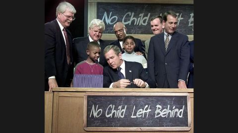 President George W. Bush waves from the stage during a bill-signing ceremony for the No Child Left Behind Act during a visit to Hamilton High School in Hamilton, Ohio, on January 8, 2002. "Leave No Child Behind" was a popular slogan during Bush's presidential campaign. 