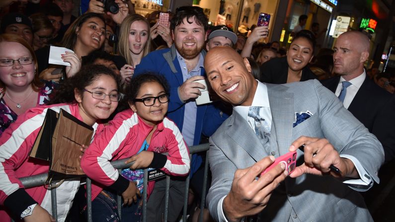 Actor Dwayne Johnson takes a selfie with fans at the Los Angeles premiere of "Furious 7" on Wednesday, April 1.