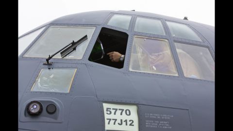 Lockheed Martin pilot Steve Knoblock points out features inside the cockpit of the MC-130J Super Hercules Commando II.