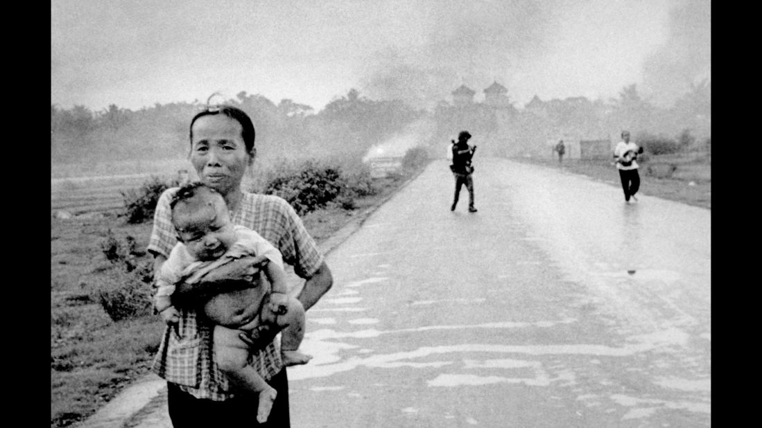 Women carry severely burned children down the road after the attack.