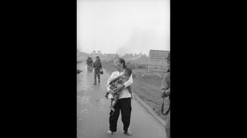 An anguished woman carries her napalm-burned child.