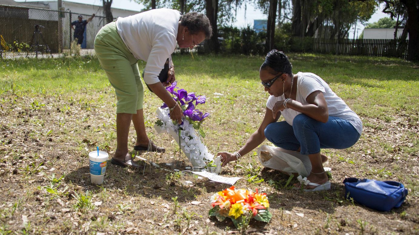 Scott's cousin Barbara, right, and her mother, Evaliana Smalls, lay flowers at the lot where the shooting took place.