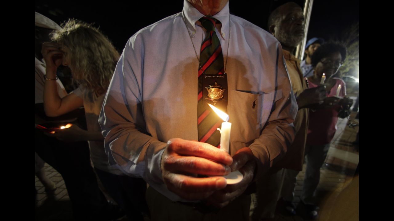 Charleston County Sheriff Al Cannon holds a candle as he joins the City Hall protest on April 8.