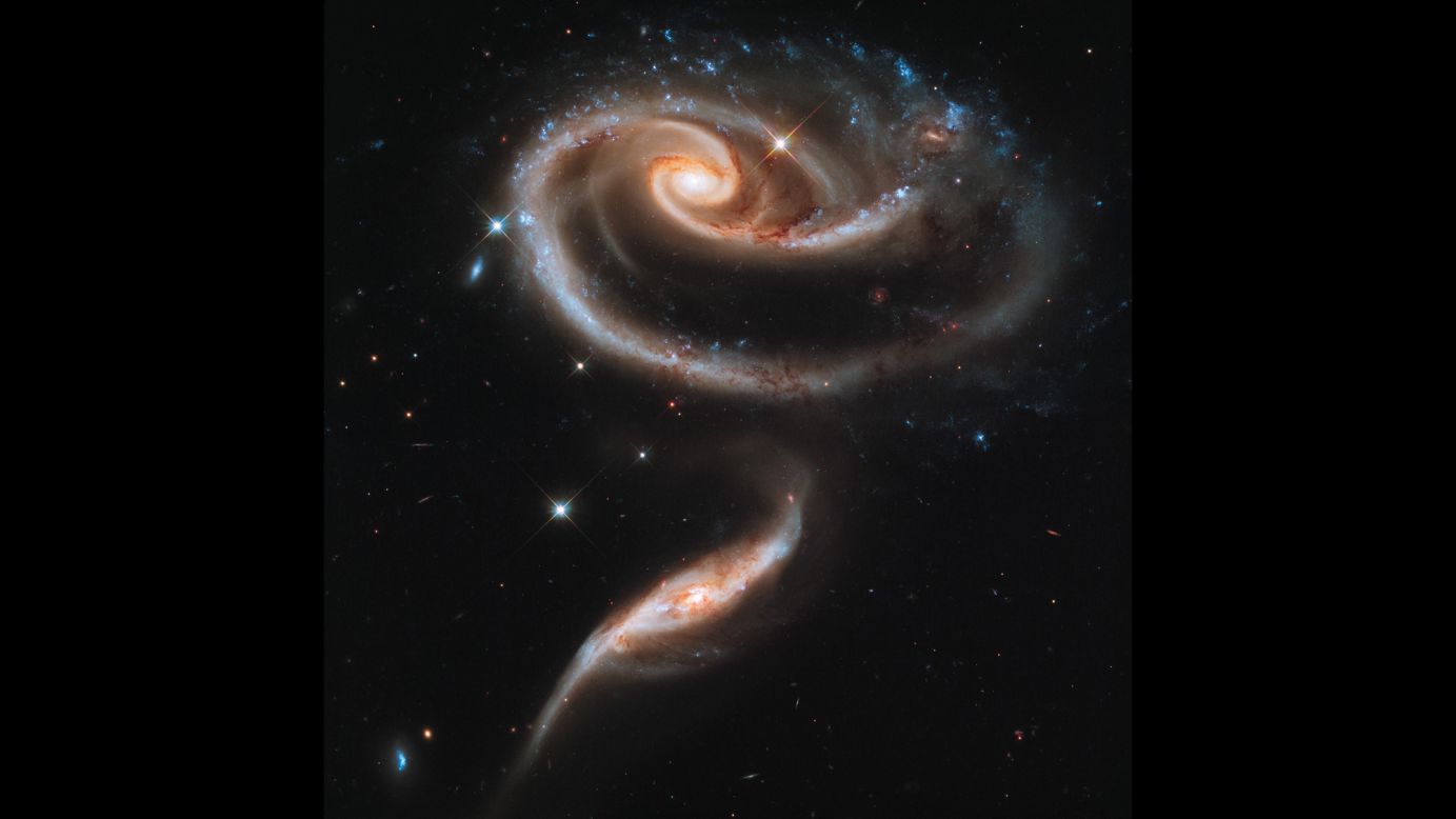 Hubble captured this image of a group of interacting galaxies called Arp 273. The bigger galaxy has a center disk that is distorted into a rose-like shape by the pull from its partner below. 
