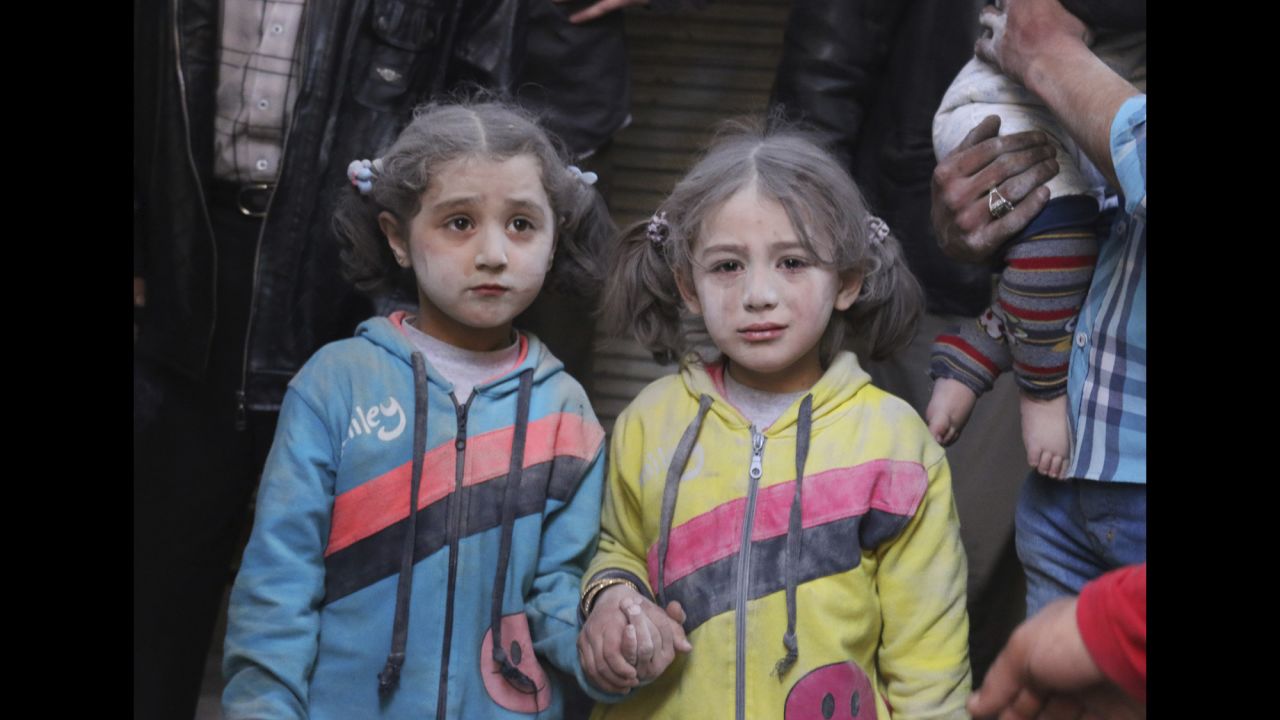 Girls in Aleppo, Syria, hold hands after surviving what activists said was a missile attack carried out Tuesday, April 7, by the forces of Syrian President Bashar al-Assad. Syria has been mired in civil war since 2011.