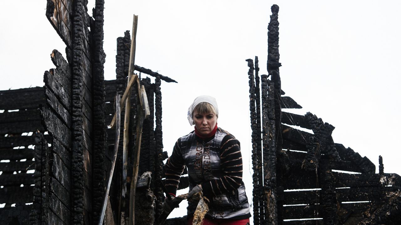 A woman in Donetsk, Ukraine, removes debris from the roof of a house that was damaged by shelling on Monday, April 6. Fighting between Ukrainian troops and pro-Russian rebels in the country has left thousands dead since April 2014.