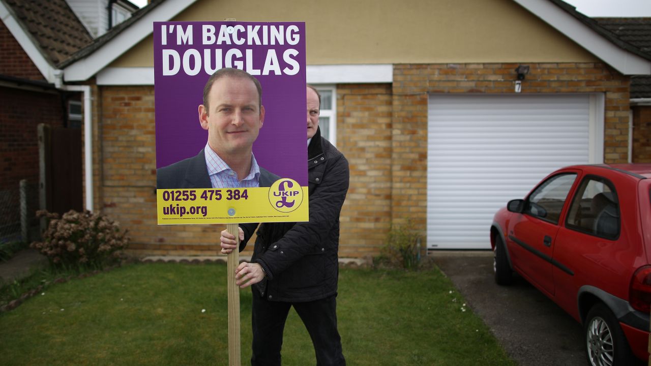 Parliament member Douglas Carswell puts one of his campaign signs in a supporter's yard Wednesday, April 8, in Clacton-on-Sea, England.