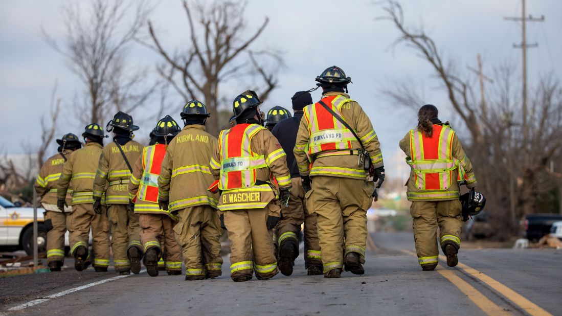 The Kirkland Fire Department walks along a highway while searching for unaccounted people in Fairdale on April 10.