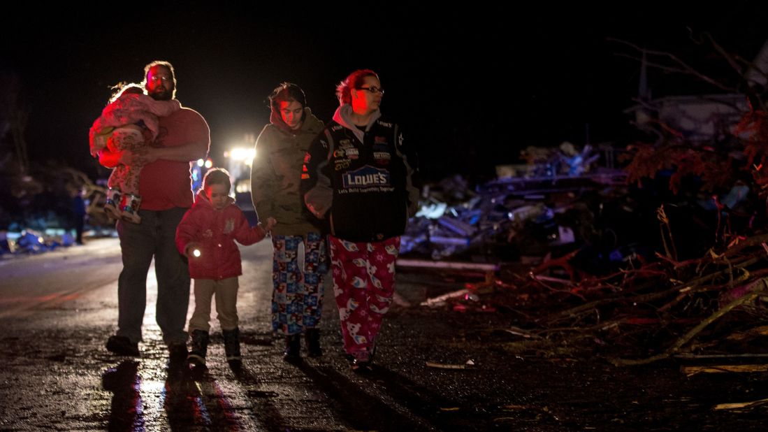 A family surveys the wreckage in Fairdale on April 9.