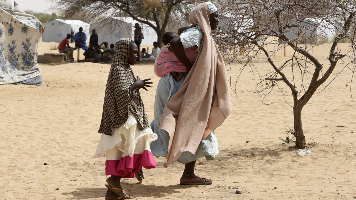 In this picture taken on April 7, 2015, Nigerian refugees walk in a camp named Dar-es-Salam in the Chad lake region. 