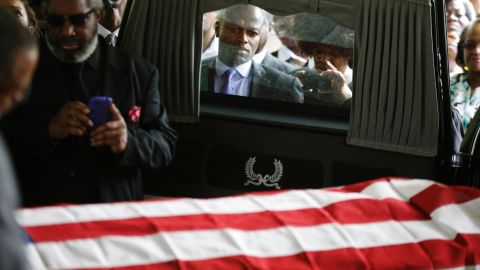Mourners look on as the casket of Walter Scott is removed from a hearse for his funeral at W.O.R.D. Ministries Christian Center, April 11, 2015 in Summerville, South Carolina. Scott was killed by a North Charleston police officer after a traffic Saturday, April 4, 2015. The officer, Michael Thomas Slager, has been charged with murder. 
