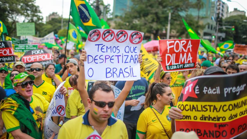 Demonstrators take part in a protest againt Brazilian President Dilma Rousseff in Porto Alegre, Brazil on April 12, 2015. Tens of thousands of Brazilians turned out for demonstrations Sundays to oppose leftist president Dilma Rousseff, a target of rising discontent amid a faltering economy and a massive corruption scandal at state oil giant Petrobras. The signs read 'We have to clear of the PT rats', 'Dilma out and take the PT with you' and 'It is easy to preach to be socialist / communist with the money of others and worse: stealing the people'. AFP PHOTO / Jefferson BERNARDES (Photo credit should read JEFFERSON BERNARDES/AFP/Getty Images)