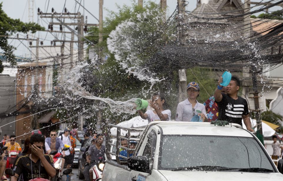 Locals in the back of pickup trucks throw water at pedestrians to celebrate the Thai new year on Koh Samui, an island in Thailand's Surat Thani province. 