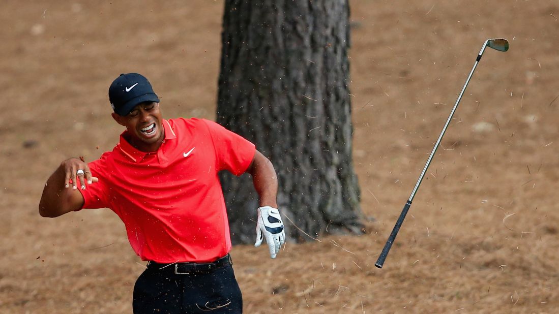 Woods winces in pain after striking a tree root with his club after a shot from the rough in the final round of the 2015 Masters Tournament in April. He tied for 17th place.