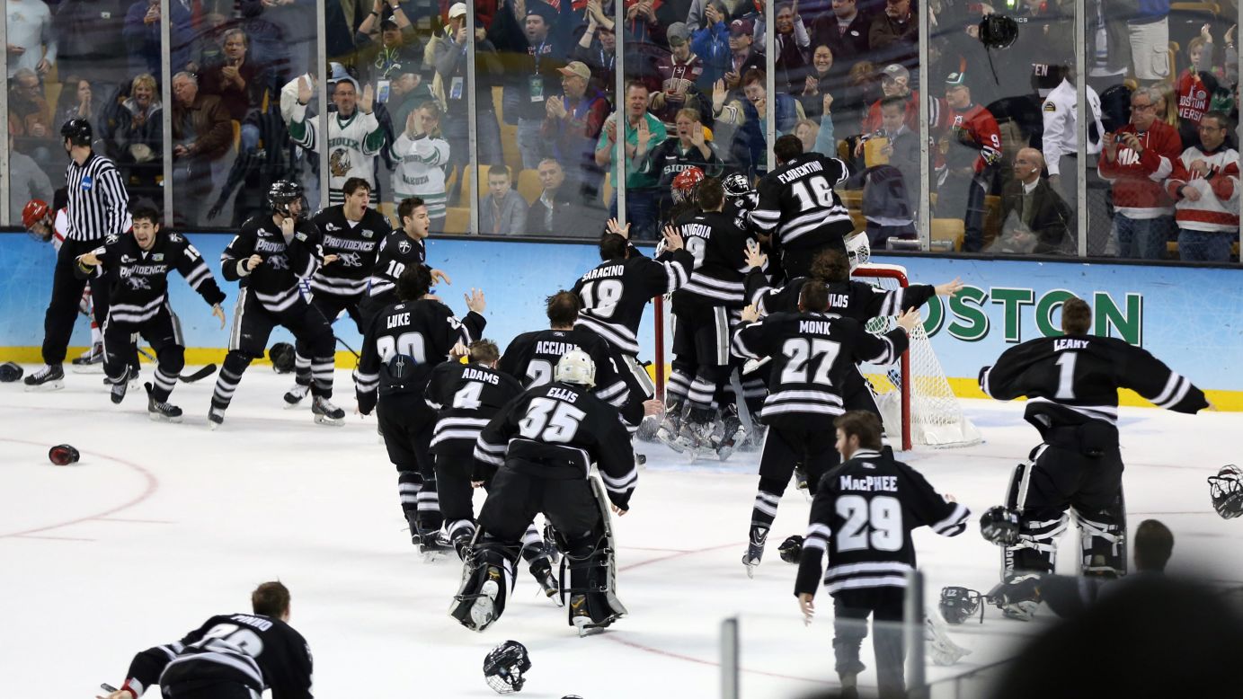 Providence hockey players mob their goalie, Jon Gillies, after they defeated Boston University on Saturday, April 11, to win the school its first hockey championship. Gillies had 49 saves in the 4-3 victory.