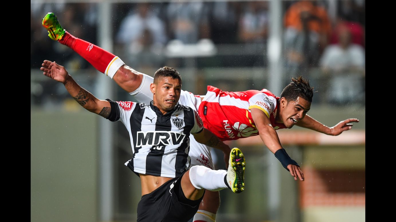 Santa Fe's Jose Anchico, top, falls over Atletico Mineiro's Carlos during a Copa Libertadores match played Thursday, April 9, in Belo Horizonte, Brazil. Carlos scored a goal in the match, which ended 2-0.