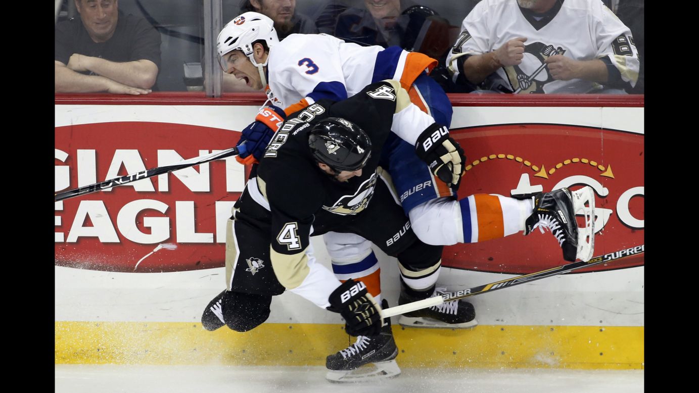 Pittsburgh's Rob Scuderi hip-checks Travis Hamonic of the New York Islanders during an NHL game in Pittsburgh on Friday, April 10.