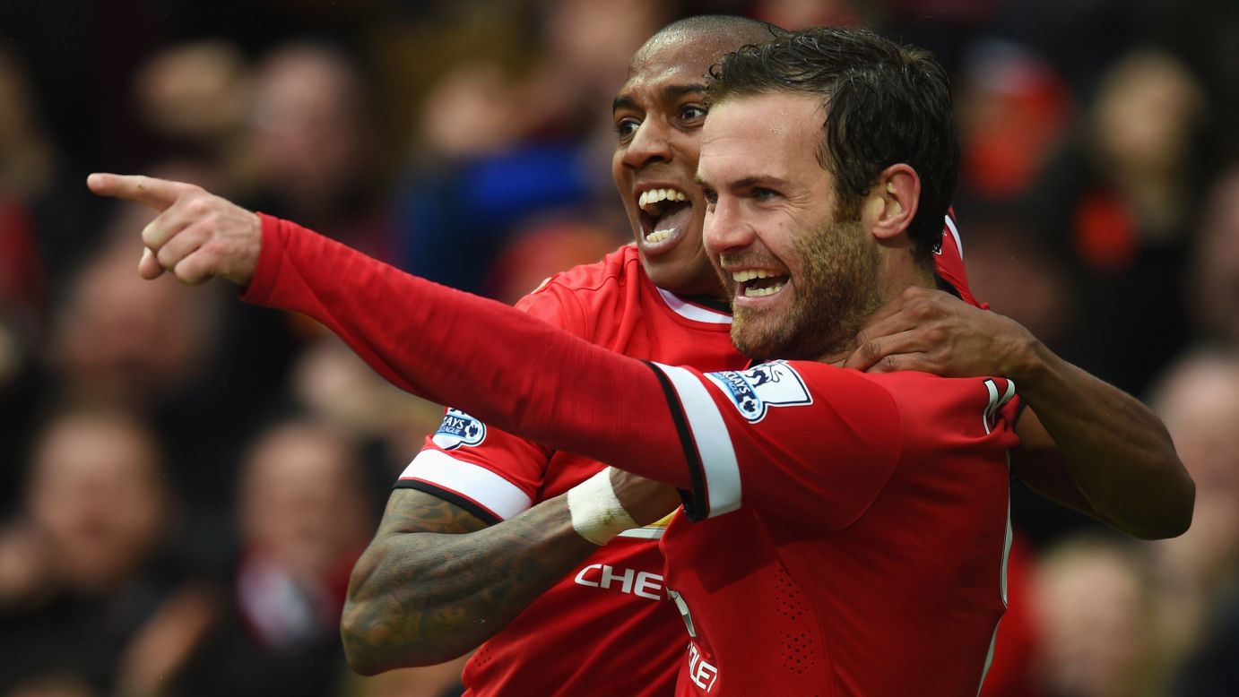 Manchester United's Juan Mata points to a teammate as he and Ashley Young celebrate his goal Sunday, April 12, in Manchester, England. United's 4-2 home victory over Manchester City moved them four points ahead of their crosstown rivals in the Premier League.