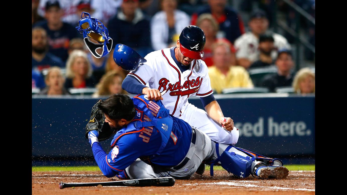 Andrelton Simmons of the Atlanta Braves collides with Travis d'Arnaud of the New York Mets as he is tagged out at home during the Braves' home opener on Friday, April 10.