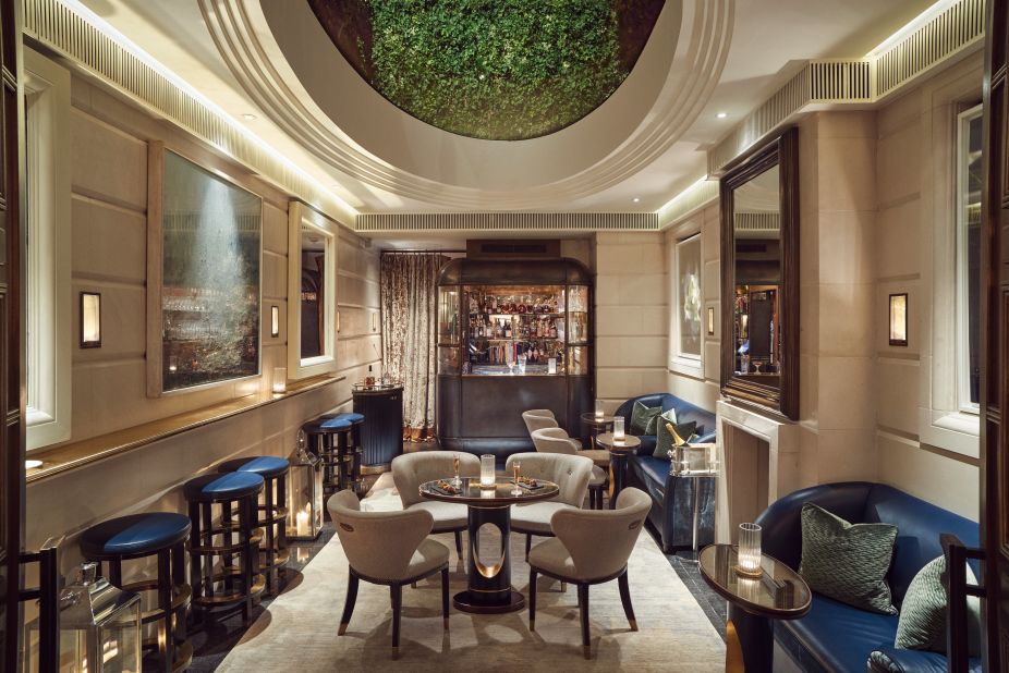 Accessed via a velvet curtain, the tucked-away bar is illuminated by an overhead skylight and has lustrous brass, leather accents and limestone floors.  
