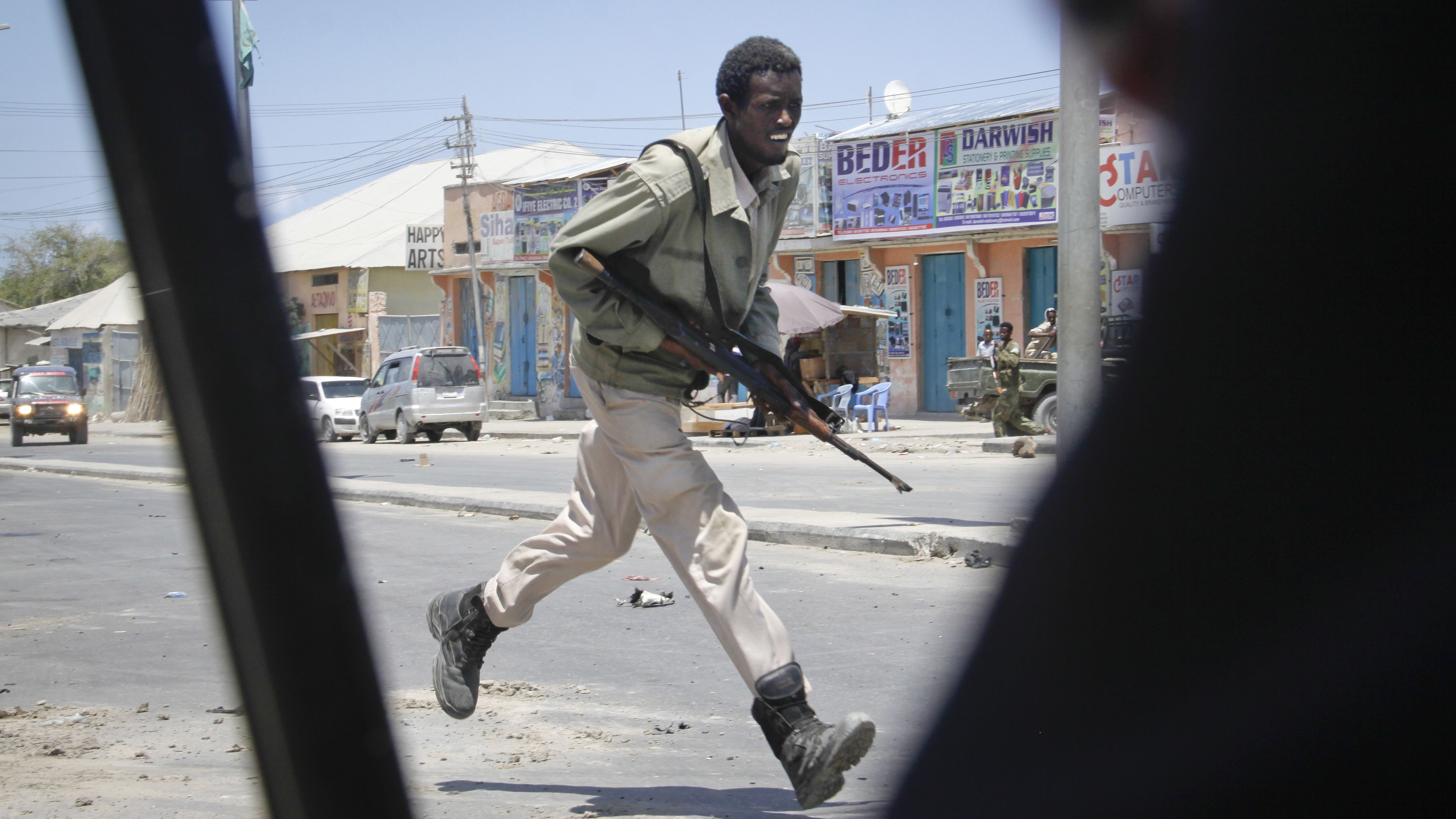 A Somali soldier runs during fighting following a car bomb explosion Tuesday.