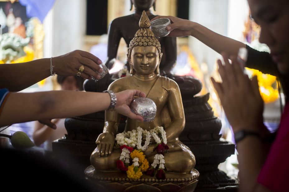 Visitors offer prayers at Wat Boworn during the Songkran festival in Bangkok. On the first day of festivities, many families and friends celebrate by visiting temples and pouring water on each others' hands as a blessing. People also pour water -- a symbol of cleansing and purification -- over Buddha statues. 