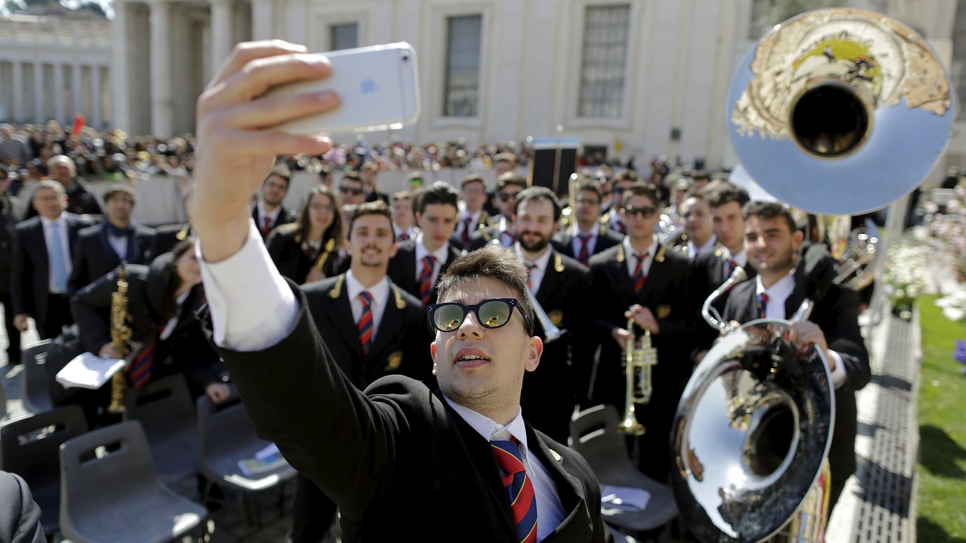 A musician snaps a photo with other members of his band on Wednesday, April 8, during Pope Francis' general audience at the Vatican.