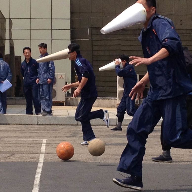 Yanggakdo hotel workers wearing conical masks play a game on April 15.
