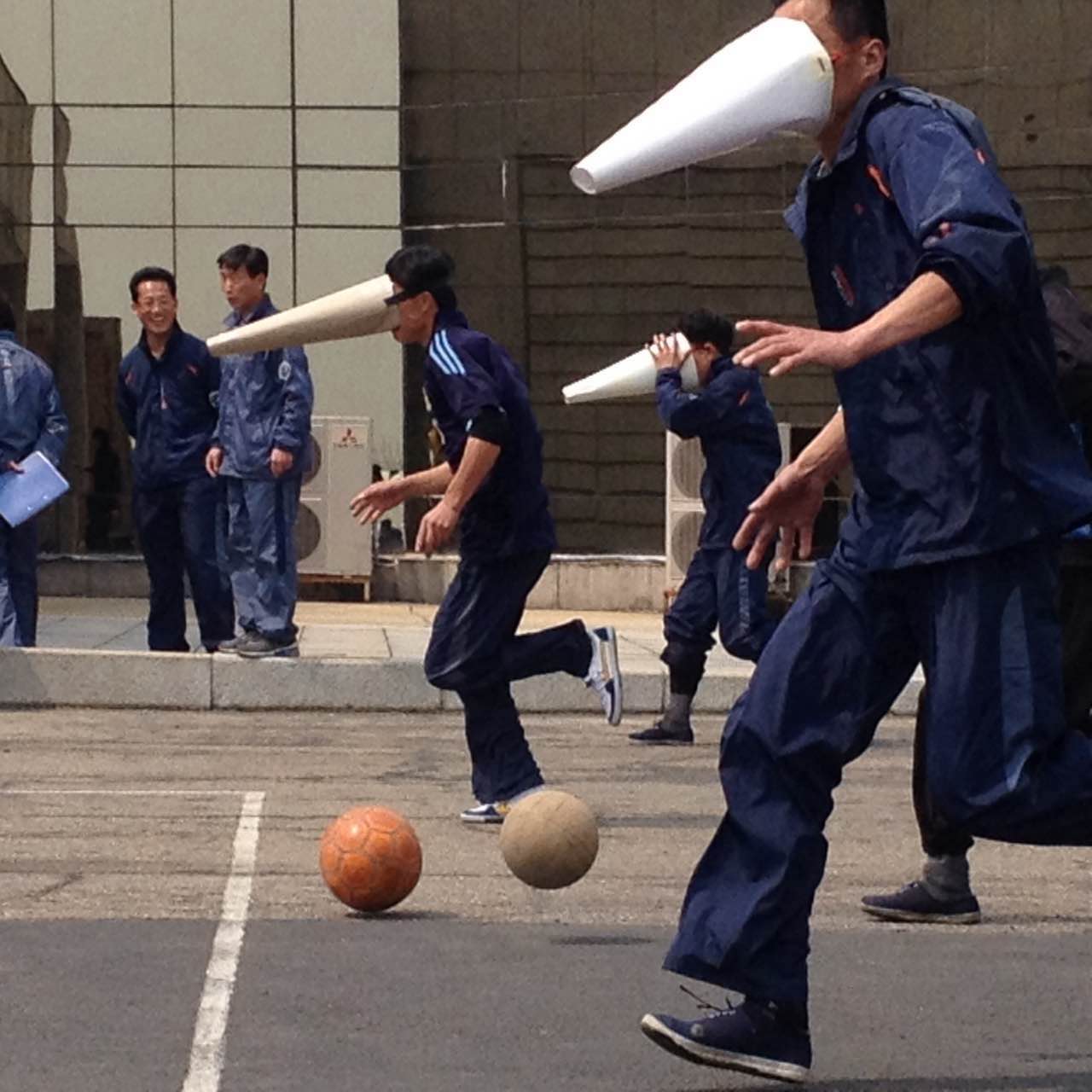 Los trabajadores del hotel Yanggakdo llevan puestas máscaras en forma de cono mientras participan en un juego el 15 de abril. 