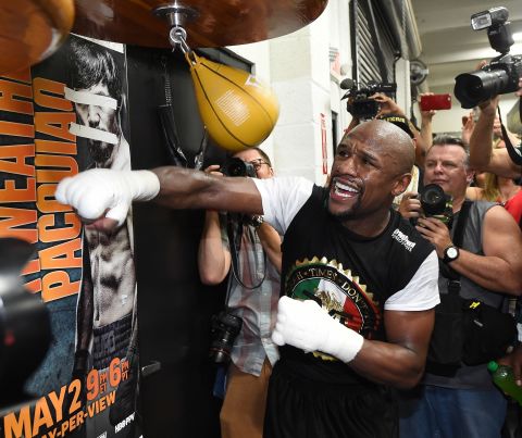 Showing off in front of the reporters, Mayweather pummels a speed bag. Look closely, and you'll see a poster of Pacquiao with his eyes and mouth taped over.