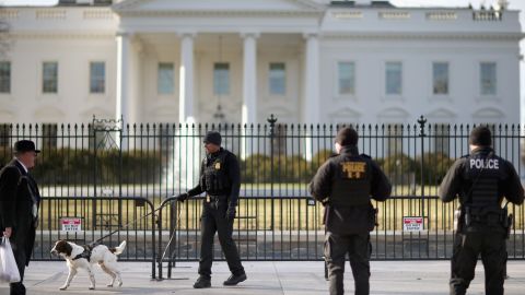 A US Secret Service K-9 team works along the second, temporary fence on the north side of the White House March 18, 2015, in Washington.