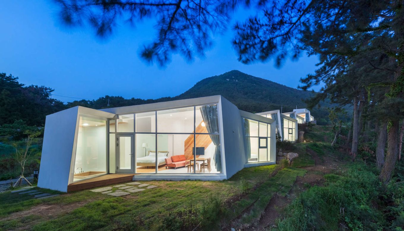 Designed by Atelier Chang, Knot House is made up of five white, sculptural buildings that rest on a cliff on the southern coast of Geoje Island. The white walls fold in on themselves to create a private ocean view from each house. 