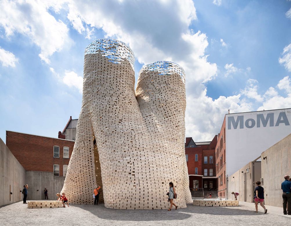 Design firm By The Living was commissioned by New York's Museum of Modern Art and MoMA PS1 to create this circular tower of organic bricks. "The structure is an extension of the natural Carbon Cycle, with a revolutionary new construction material that grows out of living materials and returns to the earth through composting at the end of the structure's lifecycle," says By The Living.