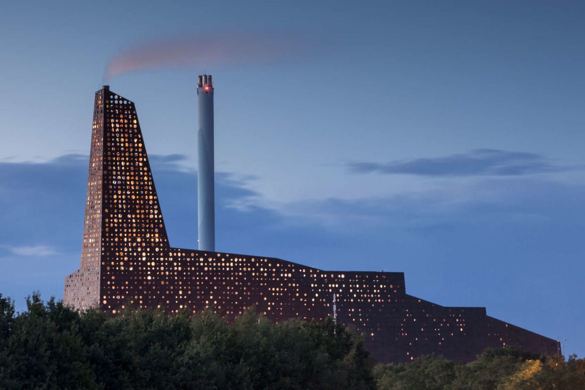 it's not often that an industrial power plant makes you want to grab your camera. The design for this new Incineration Line in Roskilde, by (designed by) Erick van Egeraat, features laser-cut circular openings that cover the raw umber-colored aluminum facade. At night, back lighting turns the incinerator into a glowing beacon, symbolizing the energy production going on inside the facility. 